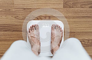 Top view, a man using body scale checking body weight, dieting and lose weight concept