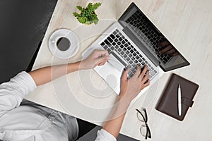 Top view of man using a modern portable computer in home office