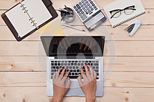 Top view of man using a modern portable computer in home office