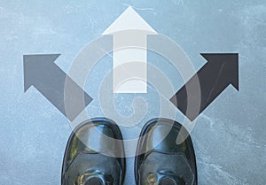 Top view of man wearing black shoes choosing a way marked