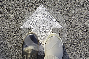 Top view of man wearing black and white shoes choosing a way marked with white arrows. Chooses the right path concept