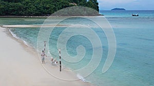 Top view of a man and a woman in a happy relaxing in a hammock on the beach on vacation at Phi Phi Island, Thailand