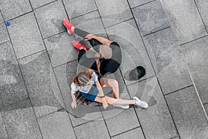 Top view man and woman sitting on a longboard