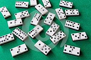 Top view of many domino pieces on green mat to play