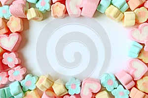 Top View of Many Pastel Color Flower Shaped and Heart Shaped Marshmallow Candies with Free Space for Text and Design