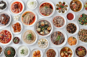 Top view of many plates on dinner dishes from different dishes covered in sauce on white background photo
