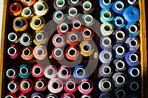 Top view of many reels of threads for embroidery or sewing, colorful background