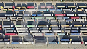 Top view of many trucks with trailers waiting to be unloaded at the port terminal.