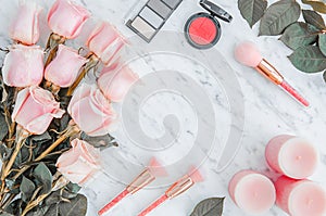 Top view marble background with beautiful roses. pink candles and cosmetics. Flat lay