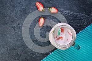 A top view on a mason jar with jogurt on a marble background. Food concept.