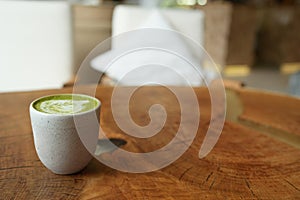 Top view of matcha green tea latte with a latte heart art on wooden table cafe background