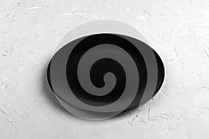 Top view of matte round empty black plate on dark cement background copy space for you design. Perspective view