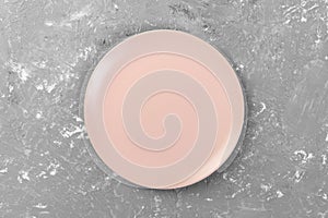 Top view of matte round empty pink plate on dark cement background space for you design