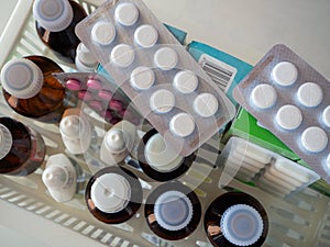 Top view on medical drugs. Pills, tinctures, gels and other medicines stand on a shelf. Medical background.