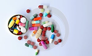 Top view of Medicines in bottle cover cap, colorful pills, tablets and capsules isolated in white background. Drug prescription.