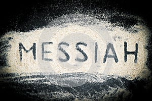 Top view of Messiah word written on sand photo