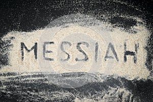 Top view of MESSIAH word written on white sand photo