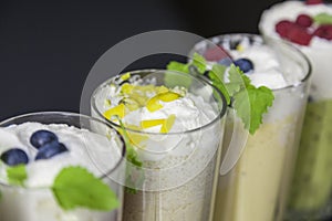 Top view on milk cocktails with blueberries, raspberries and mint leaves