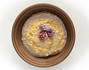 Top view on millet porridge cocked with slices of pumpkin