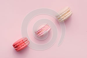 Top view of mini pink and white macaron on soft sweet pink paper