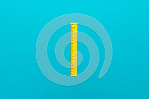 Top view minimalist photo of yellow plastic ruler with central composition