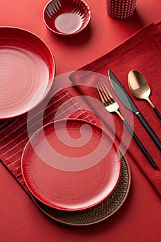 Abstract food background with red plates and cutlery on red table photo