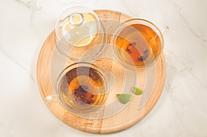 Top view of mint tea in glass with lemon/Top view of mint tea in glass with lemon on a wooden tray. Top view