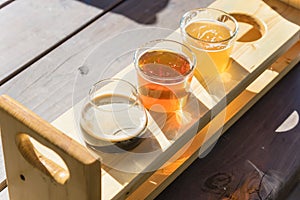 Top view mixed of draft beers in tasting sampler tray on wooden picnic table of brewery in Texas, USA