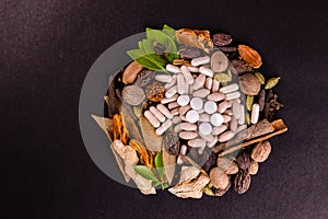 Top view of mixed herbal medicines and natural herbs on a black background with copy space. Ayurvedic and herbal medicines concept