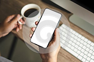 Top view Mockup image hand using a smartphone man Holding Cell Phone With Blank Screen