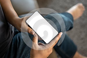 Top view Mockup image hand using a smartphone man Holding Cell Phone With Blank Screen