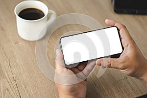 Top view Mockup image hand using a smartphone man Holding Cell Phone With Blank Screen