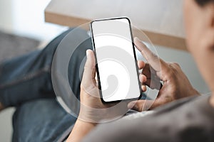 Top view Mockup image hand using a smartphone man Holding Cell Phone With Blank