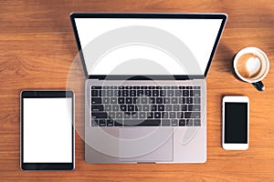 Top view mockup image of laptop with blank white screen , tablet pc , mobile phone and coffee cup