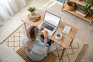 Top view mockup image of a woman working and typing on laptop computer with blank screen at home photo