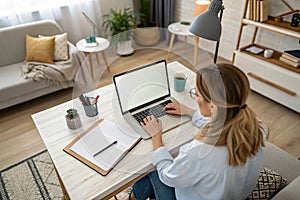 Top view mockup image of a woman working and typing on laptop computer with blank screen at home photo