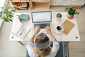 Top view mockup image of a woman working and typing on laptop computer with blank screen at home photo