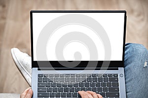 Top view mockup image of woman working and typing on laptop computer with blank screen while sitting on a sofa at home