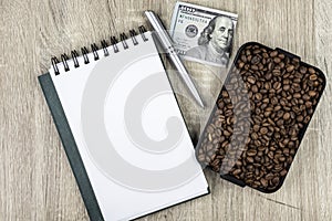 Top view mockup of open blank notebook on spiral, automatic pen. 100 dollar banknotes and samples rosted coffee beans
