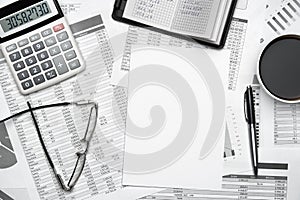 Top view of modern black office desk with notebook, pencil, financial statements and a lot of things. Flat lay table layout