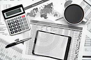 Top view of modern black office desk with notebook, pencil, financial statements and a lot of things. Flat lay table layout