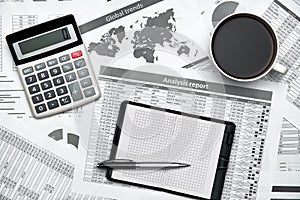 Top view of modern black office desk with notebook, pencil, financial statements and a lot of things. Flat lay table layout