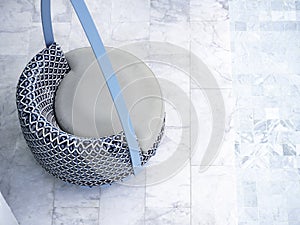 Top view of modern blue round rattan seat on the marble tiles floor.