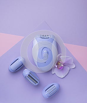 top view of Modern epilator on purple background. skin care, removal of unwanted hair.