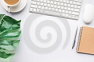 Top view modern office desk table with tropical leaves