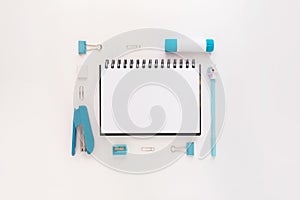 Top view of modern white blue office desktop with school supplies and stationery on table around empty space for text. Back to