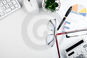 top view of modern white desk with office equipment and report papers on white background.