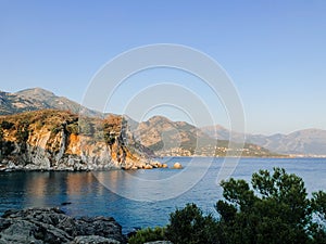 Top view Montenegro Sutomore stones beach blue turquoise Adriatic sea water mountains on sunset.