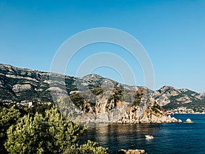 Top view Montenegro Sutomore stones beach blue turquoise Adriatic sea water mountains on sunset.