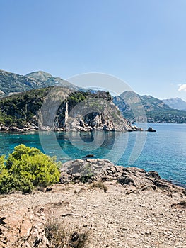 Top view Montenegro Sutomore stones beach blue turquoise Adriatic sea water mountains on sunset.